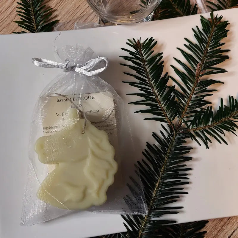 Savon licorne joliment emballé dans son sachet en organza dans une assiette