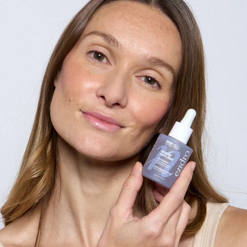 Femme tenant le sérum repulpant dans la main