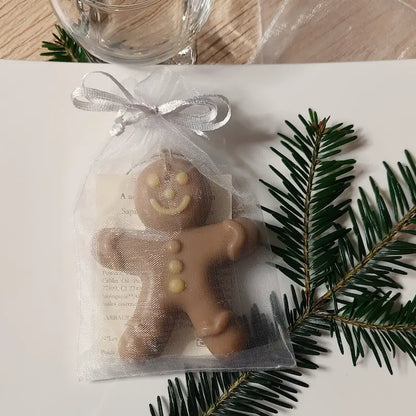 Savon en forme de bonhomme en pain d'épices dans son sachet en organza présenté à table comme cadeau invité